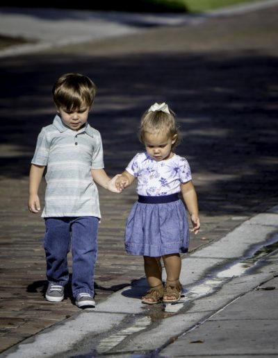 Two toddlers walking hand and hand