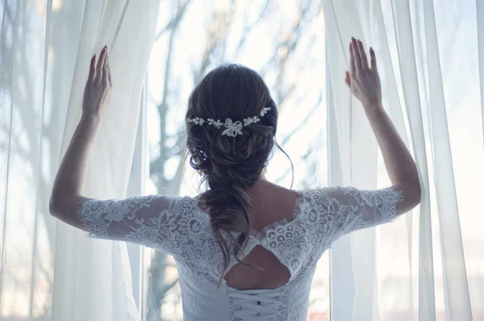 BRIDE LOOKING OUT A WINDOW